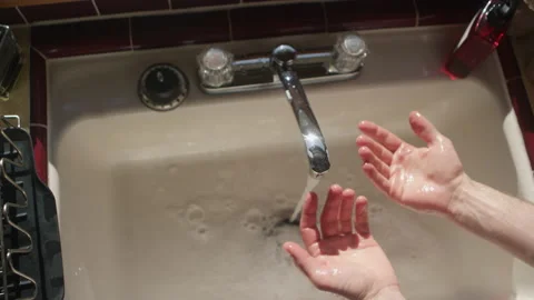 POV looking down at wet hands after washing them in the sink Video stock 134278219