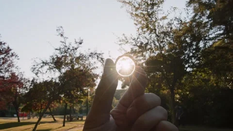 POV looking at an engagement ring against the backdrop of a sunset in a park in Stock Footage 245228922