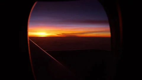 POV looking out from airplane window to dark sky and sunset Stock Footage 309359536