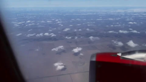 Pov looking through porthole of flying plane at a picturesque landscape with Stock Footage 291131213
