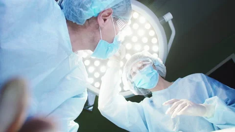 POV low angle view of patient being operated by two professional surgeons Stock Footage 227203265