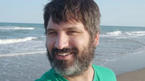 Pov of a man with a beard is recorded with the mobile on the beach Stock Footage 168106262