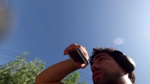 Pov of a man cleaning his camera lens with his shirt while running with headphon 库存影片 199546233