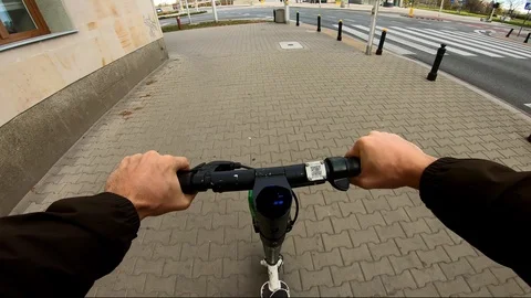 POV man on electric scooter stopped at the crosswalk Stockbeeldmateriaal 121122753