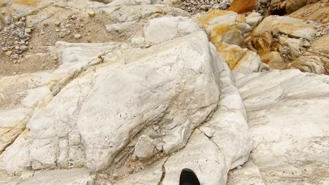 POV man goes down jump rocks small clear stream high mountains of Himalaya Stock Footage 106110617