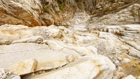 POV man goes down rocky gorge holds on stone small clear brook high mountains Hi Stock Footage 106110669