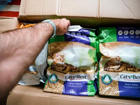 POV man hand taking from the parcel two packages cat litter Stock Photos