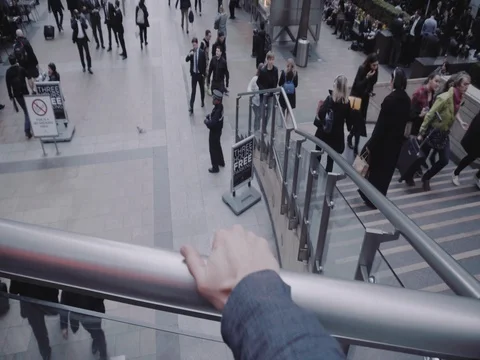POV of a man looking over a square full of people at Canary Wharf Stock Footage 74669457