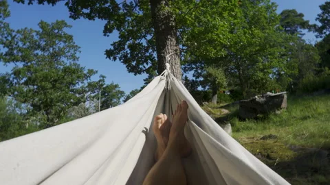 POV of man lying in white hammock in garden forest, sunny summer day Stock Footage 211876987