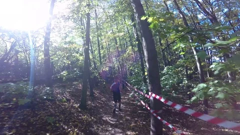 POV - a man runs down a track through a forest at a race Stock-Footage 87455045