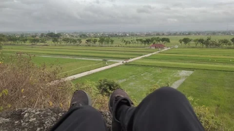 POV of A Man Sitting Casually on The Rocks of A Hill Stock Footage 316877930