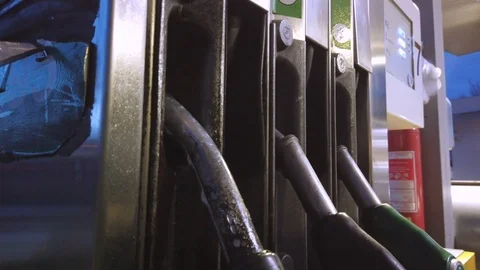 A POV as a man takes the handle of a gas pump at a petrol station and Stock Footage
