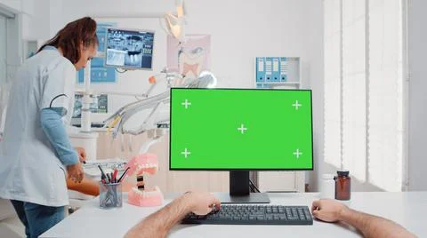 POV of man using keyboard and computer with green screen Stock Photos