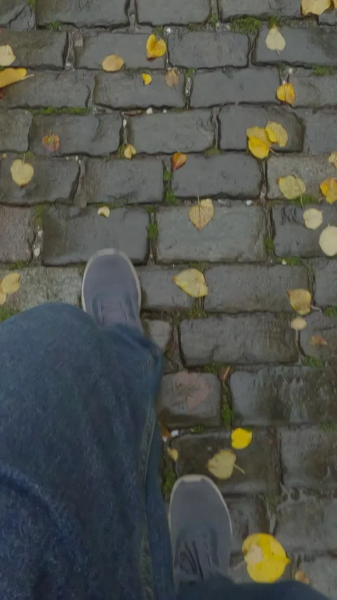 POV, men feets are dressed in jeans and boots walks along wet sidewalk with Stock Footage 320529845