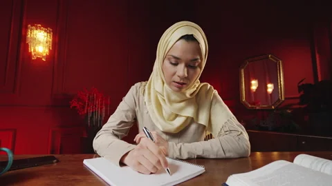 POV of Middle Eastern female student taking online class, writing in notebook Stock-Footage 343986121