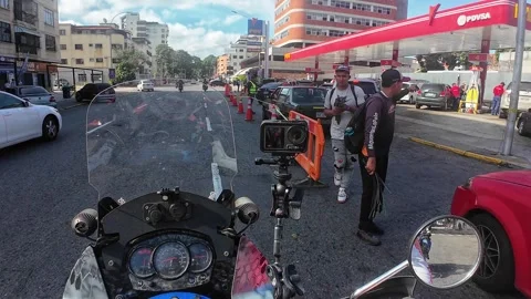 POV motorcycle approaching a long queue at Los Chaguaramos gas station in Stock Footage 327415891