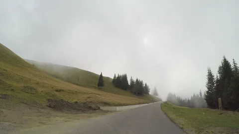 POV of mountain forest road seen from car driving through fog and mist in a g Stock Footage 86218641