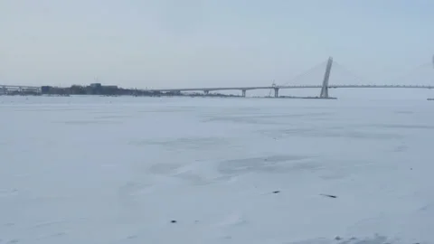 POV, moving above the ice, view of frozen bay with big bridge Stock-Footage 100214675