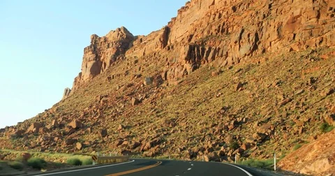 POV moving driving down curvy road by red cliffs rocks desert Four corners 4K Stock Footage 78084387