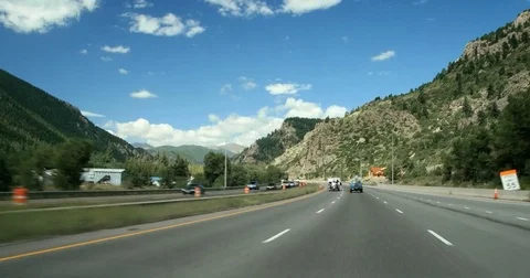 POV moving driving down green mountain highway spring summer blue sky day I-70 Stock Footage 73869859