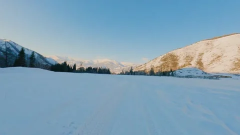 Pov moving through a snowy mountain valley at sunrise Stock Footage 346636393