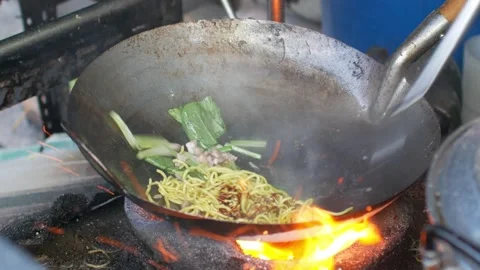 Pov to a pan while local chef cooking fried noodle in Phuket local style Stock Footage 289812217