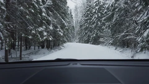 POV of a passenger from inside the cabin of a car driving along a winter narrow Stock Footage 296335543