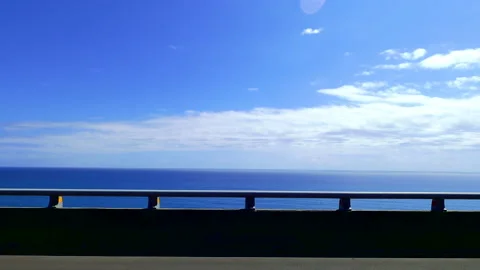 POV-Passenger side window driving scene. blue ocean against  blue sky Stock Footage 149633469