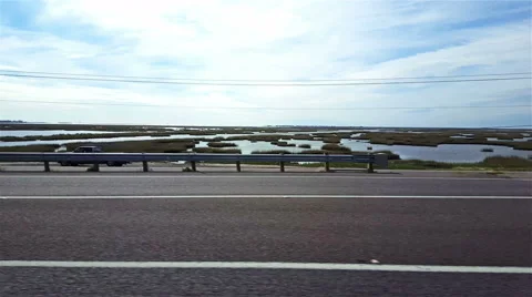 POV-passenger side window passing wet land on causeway to Galveston, Texas Stock Footage 57943130