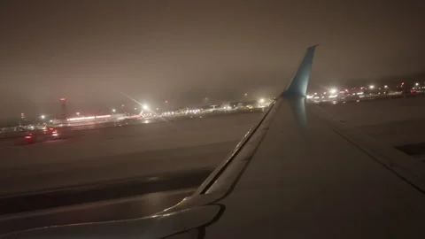 POV of a passenger through a window from an airplane landing at night. The Stock Footage 309016230