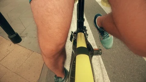 POV of pedaling male legs. Man cycling along city bike path Stock Footage