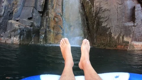 POV person floating under Python pool waterfall 動画素材 205540005