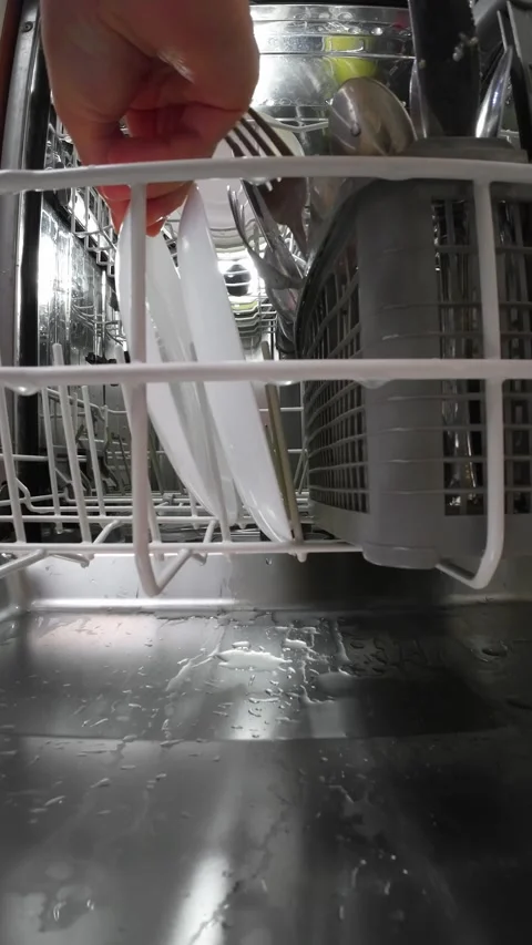 POV person loading white dish rack inside household dishwasher after washing Stock Footage 329559449