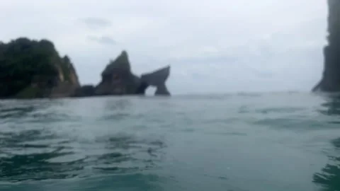 POV person panic in open sea drifting between wild beach and rocks. Stream Stock Footage 252535601