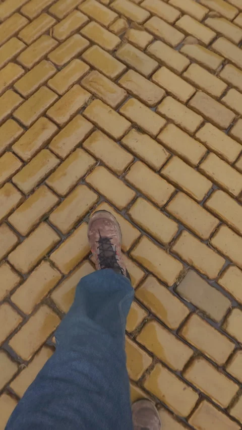 POV: person's legs walking on damp along vintage pavement covered with yellow Stock Footage 321604604