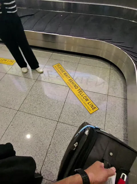 POV Picking up Suitcase at the baggage claim Stock Footage 307828500