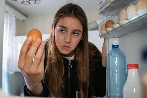 POV point of view from inside refrigerator Caucasian hungry girl adult sad upset Stock Photos