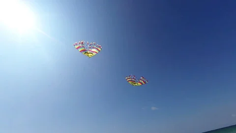 POV point of view. Two cheery and bright kite in the blue sky on the seashore Stock Footage 84733992