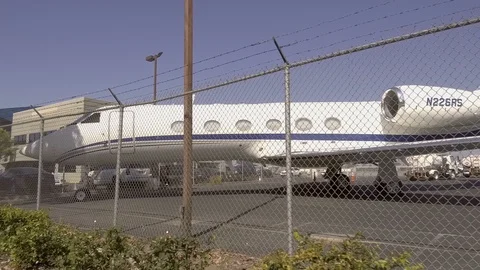 Pov Private Jets John Wayne Airport View through Fence Lines Pan Shot Stock Footage 93521597