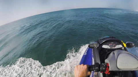 POV of professional surfer on jet ski passing by surfer swimming in ocean water Stock Footage 163045992