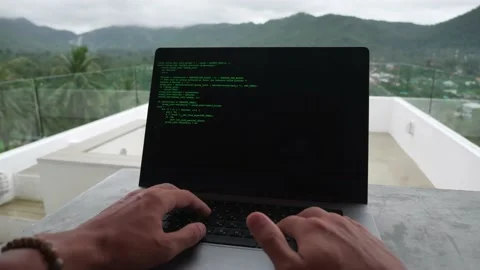 POV of programmer developer freelancer writes green code at a laptop outside the Stock Footage 193623908