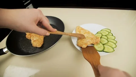 POV. Putting fried meat in breading on a plate with vegetable garnish Video stock 103487557