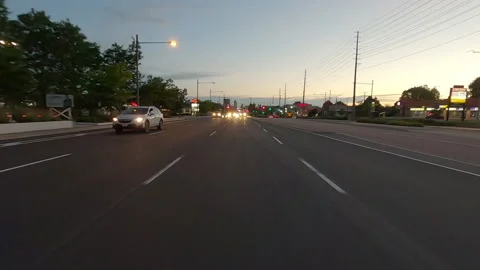 POV of reverse rear view shot driving on city streets at dusk Stockbeeldmateriaal 156478295