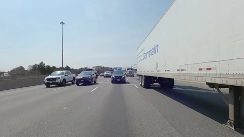 POV reverse shot driving on highway with truck and car traffic on nice day Vídeos de archivo 151888946