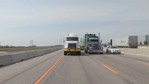 POV reverse shot driving on highway with truck and car traffic on nice day Stock Footage 151896310