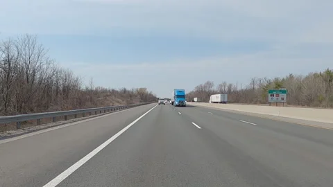 POV reverse shot driving on highway with truck and car traffic on nice day Stock Footage 151898996