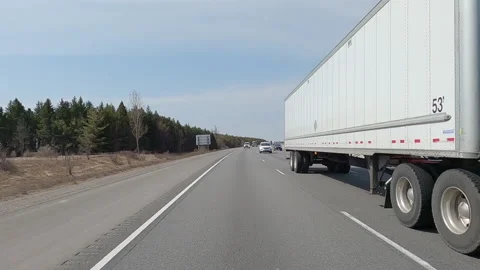 POV reverse shot driving on highway with truck and car traffic on nice day Vídeo Stock 151899215