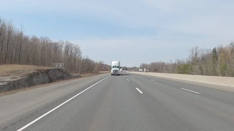 POV reverse shot driving on highway with truck and car traffic on nice day Stock Footage 151899620