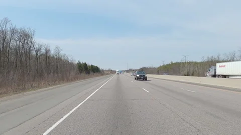 POV reverse shot driving on highway with truck and car traffic on nice day Vidéo 151900176