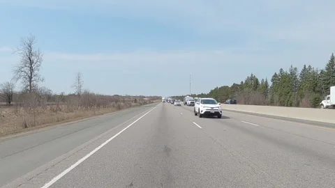 POV reverse shot driving on highway with truck and car traffic on nice day 動画素材 151900650